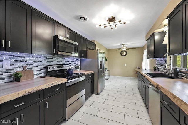 321 Justo Ln, Seven Hills, OH 44131 - kitchen with appliances with stainless steel finishes, a sink, a ceiling fan, and tasteful backsplash
