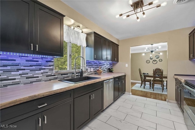 321 Justo Ln, Seven Hills, OH 44131 - kitchen featuring a chandelier, a sink, appliances with stainless steel finishes, and tasteful backsplash