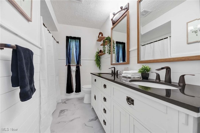 321 Justo Ln, Seven Hills, OH 44131 - bathroom featuring a textured ceiling, marble look tile flooring, double vanity, and toilet