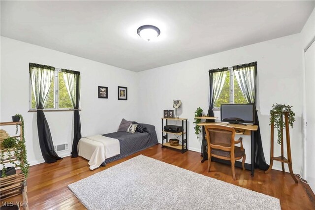 321 Justo Ln, Seven Hills, OH 44131 - bedroom with multiple windows, wood finished floors, and a desk