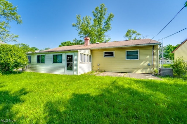24120 Sherborne Rd, Bedford Heights, OH 44146 - back of property with a chimney, a lawn, and central air condition unit