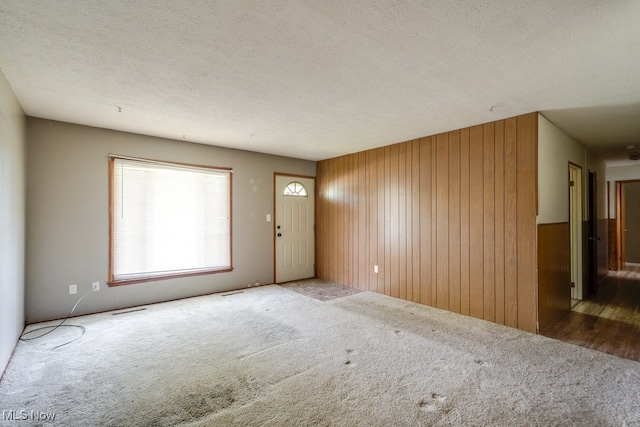 24120 Sherborne Rd, Bedford Heights, OH 44146 - foyer with carpet floors, wooden walls, and a textured ceiling