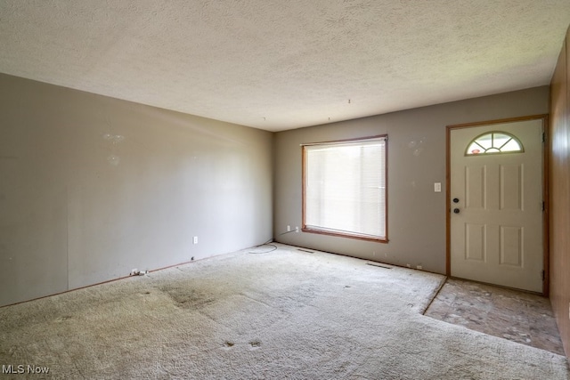 24120 Sherborne Rd, Bedford Heights, OH 44146 - entryway featuring carpet floors, healthy amount of natural light, and a textured ceiling