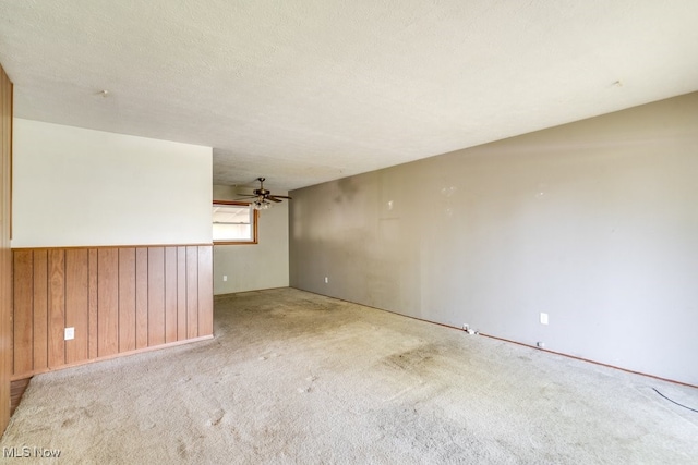 24120 Sherborne Rd, Bedford Heights, OH 44146 - unfurnished room with wood walls, a ceiling fan, and carpet floors