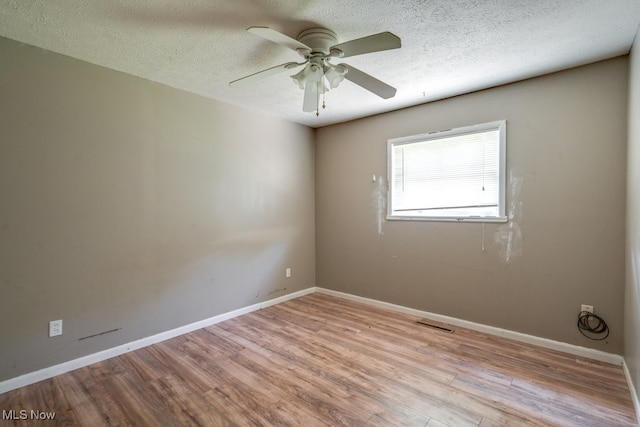 24120 Sherborne Rd, Bedford Heights, OH 44146 - unfurnished room with wood finished floors, ceiling fan, baseboards, and a textured ceiling