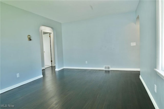 859 Gary Ave, Girard, OH 44420 - unfurnished room featuring arched walkways, dark wood-style floors, and baseboards