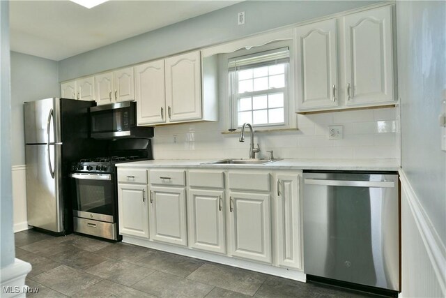 859 Gary Ave, Girard, OH 44420 - kitchen with stainless steel appliances, a sink, decorative backsplash, and white cabinetry