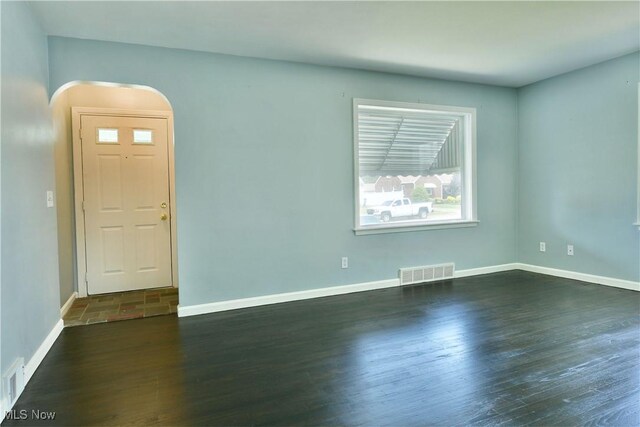 859 Gary Ave, Girard, OH 44420 - spare room featuring arched walkways, baseboards, and dark wood-style flooring
