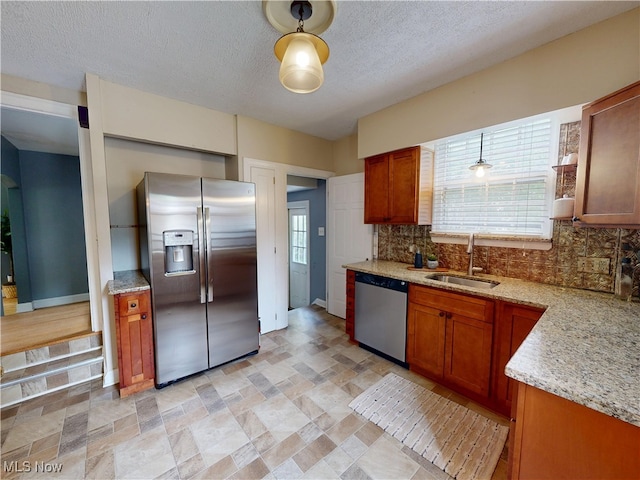 18515 Lomond Blvd, Shaker Heights, OH 44122 - kitchen featuring appliances with stainless steel finishes, a sink, backsplash, healthy amount of natural light, and a textured ceiling