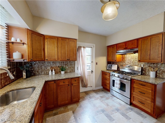 18515 Lomond Blvd, Shaker Heights, OH 44122 - kitchen with stainless steel gas stove, under cabinet range hood, a sink, backsplash, and light stone countertops