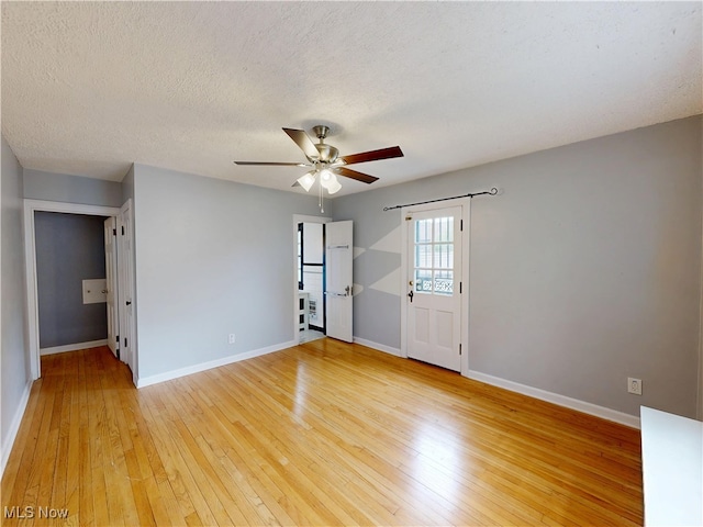 18515 Lomond Blvd, Shaker Heights, OH 44122 - empty room with light wood-style flooring, a ceiling fan, baseboards, and a textured ceiling