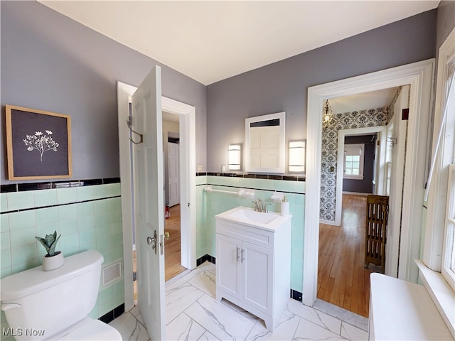 18515 Lomond Blvd, Shaker Heights, OH 44122 - bathroom featuring tile walls, vanity, toilet, a wainscoted wall, and marble look tiles