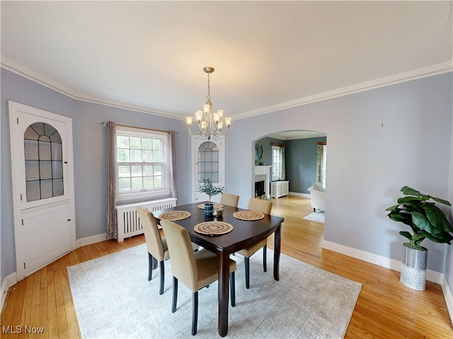 18515 Lomond Blvd, Shaker Heights, OH 44122 - dining area with arched walkways, radiator heating unit, ornamental molding, a chandelier, and light wood-type flooring