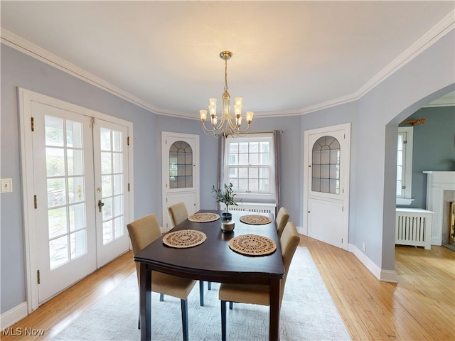 18515 Lomond Blvd, Shaker Heights, OH 44122 - dining room featuring radiator, a chandelier, light wood finished floors, crown molding, and arched walkways