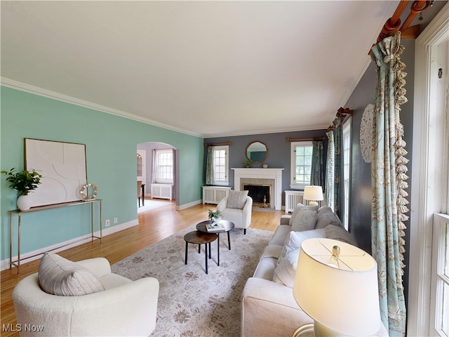 18515 Lomond Blvd, Shaker Heights, OH 44122 - living area featuring radiator, arched walkways, plenty of natural light, wood finished floors, and ornamental molding
