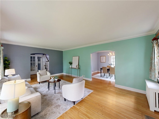 18515 Lomond Blvd, Shaker Heights, OH 44122 - living area with arched walkways, light wood finished floors, ornamental molding, and a chandelier