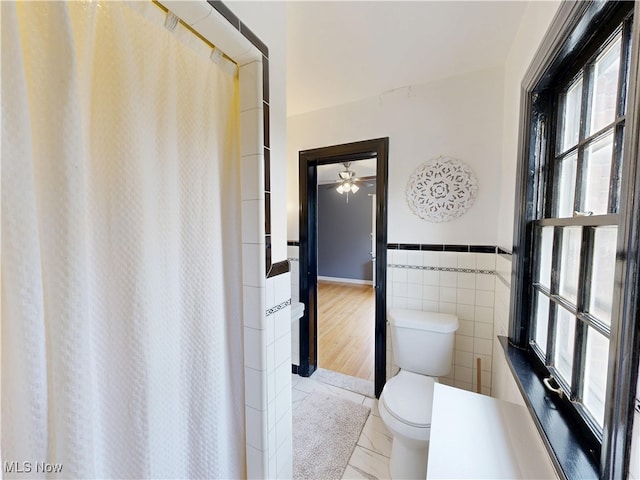 18515 Lomond Blvd, Shaker Heights, OH 44122 - bathroom featuring toilet, tile walls, tile patterned flooring, a shower with curtain, and a wainscoted wall