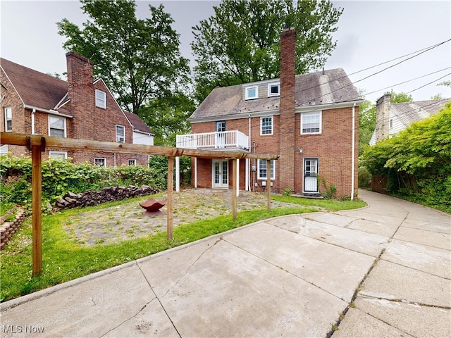 18515 Lomond Blvd, Shaker Heights, OH 44122 - rear view of property with brick siding, french doors, a chimney, and a lawn