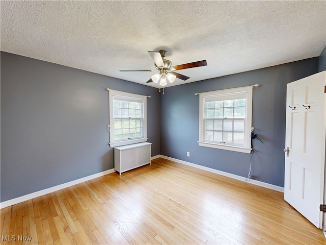 18515 Lomond Blvd, Shaker Heights, OH 44122 - unfurnished room with a ceiling fan, plenty of natural light, baseboards, light wood-style floors, and a textured ceiling