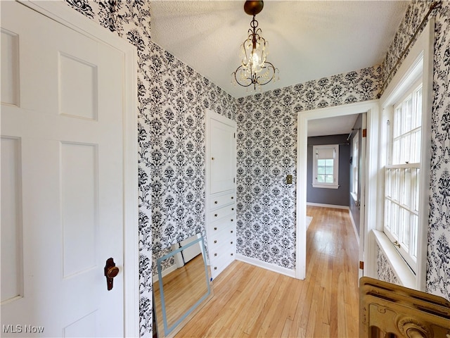 18515 Lomond Blvd, Shaker Heights, OH 44122 - foyer entrance featuring baseboards, light wood-type flooring, wallpapered walls, a chandelier, and baseboard heating