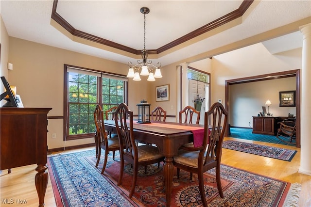 1103 Stone Crossing St NE, Canton, OH 44721 - dining room featuring ornamental molding, light wood-type flooring, ornate columns, and a raised ceiling