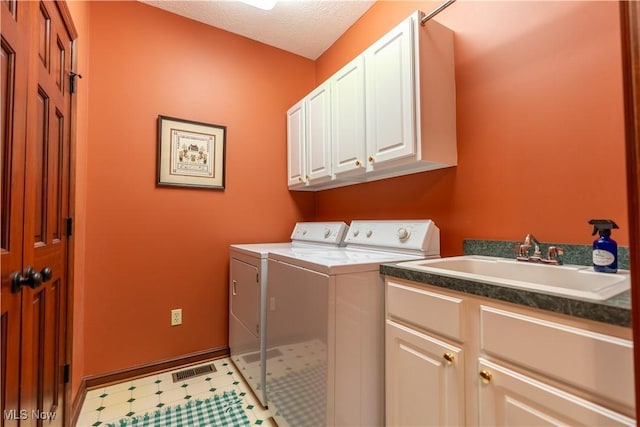 1103 Stone Crossing St NE, Canton, OH 44721 - washroom featuring cabinet space, washer and clothes dryer, light floors, baseboards, and a textured ceiling