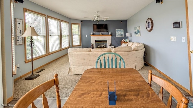 813 Buckeye Ln, Sandusky, OH 44870 - dining area featuring a fireplace, ceiling fan, carpet floors, and baseboards