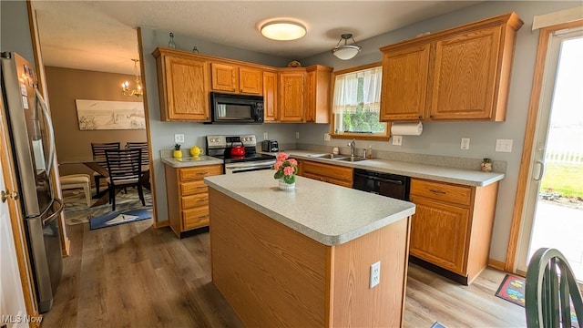 813 Buckeye Ln, Sandusky, OH 44870 - kitchen featuring black appliances, a sink, light wood-type flooring, and light countertops