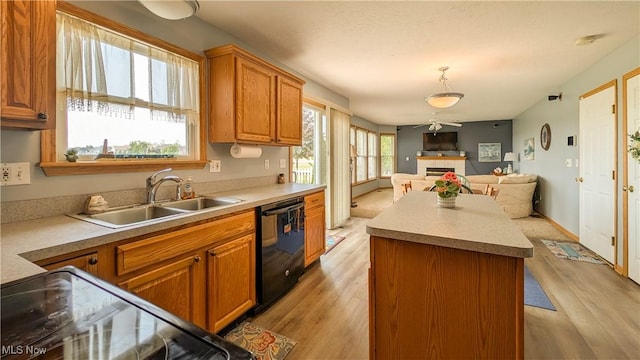 813 Buckeye Ln, Sandusky, OH 44870 - kitchen featuring black dishwasher, a sink, a fireplace, open floor plan, and light wood-type flooring