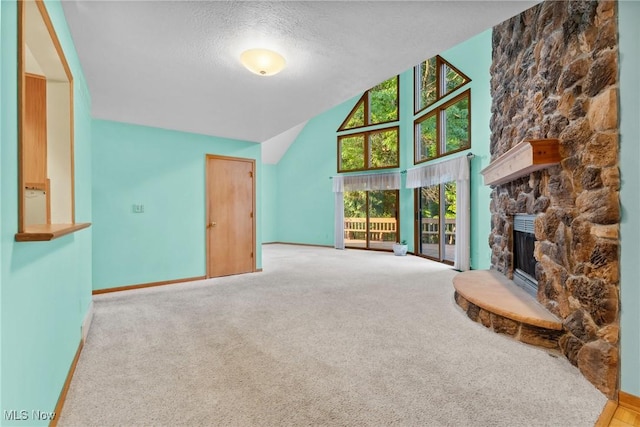 6791 Cedar Ridge Trl, Clinton, OH 44216 - carpeted living room featuring a stone fireplace, a textured ceiling, baseboards, and high vaulted ceiling