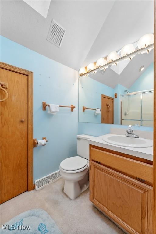 6791 Cedar Ridge Trl, Clinton, OH 44216 - bathroom with vaulted ceiling, a stall shower, vanity, toilet, and a skylight