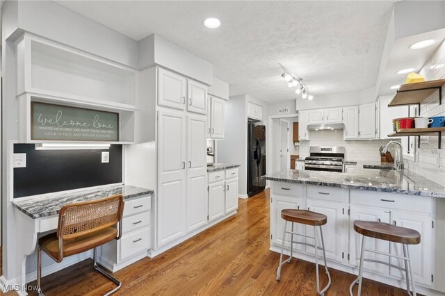 4610 Briarcliff Trl, Copley, OH 44321 - kitchen featuring stainless steel range, open shelves, under cabinet range hood, black refrigerator with ice dispenser, and a sink
