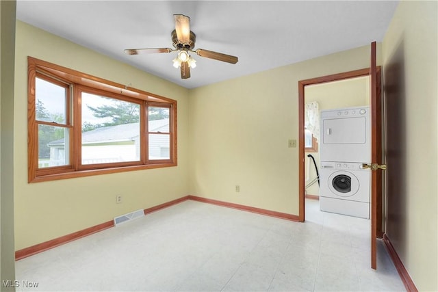 10031 Akins Rd, North Royalton, OH 44133 - empty room featuring stacked washing machine and dryer and ceiling fan