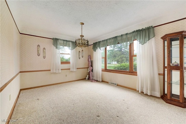 10031 Akins Rd, North Royalton, OH 44133 - empty room featuring a chandelier, healthy amount of natural light, carpet flooring, a textured ceiling, and wallpapered walls