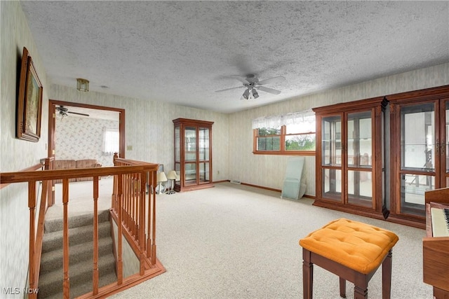 10031 Akins Rd, North Royalton, OH 44133 - living area with a ceiling fan, wallpapered walls, a textured ceiling, carpet floors, and an upstairs landing