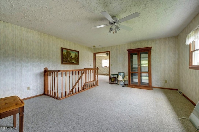10031 Akins Rd, North Royalton, OH 44133 - carpeted empty room featuring wallpapered walls, plenty of natural light, a ceiling fan, and a textured ceiling