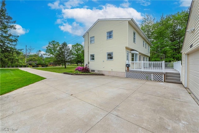 10031 Akins Rd, North Royalton, OH 44133 - back of property with a lawn, a deck, a garage, and driveway