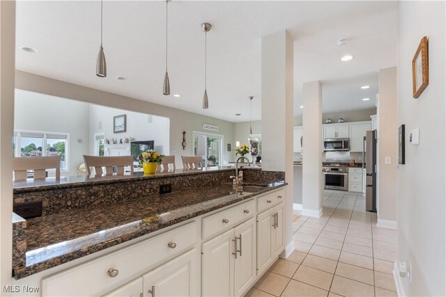 5325 S Island Dr NW, Canton, OH 44718 - kitchen with appliances with stainless steel finishes, a sink, light tile patterned flooring, white cabinets, and dark stone countertops