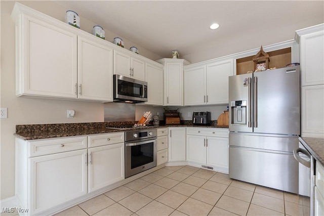 5325 S Island Dr NW, Canton, OH 44718 - kitchen featuring stainless steel appliances, light tile patterned floors, white cabinets, dark stone countertops, and recessed lighting