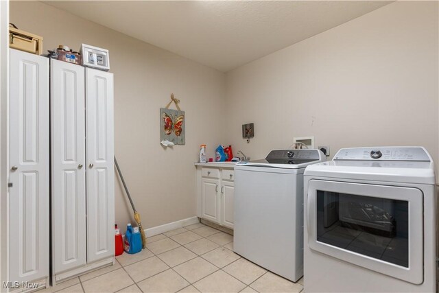 5325 S Island Dr NW, Canton, OH 44718 - laundry area with separate washer and dryer, cabinet space, light tile patterned floors, and baseboards