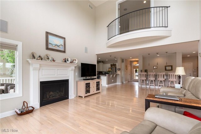 5325 S Island Dr NW, Canton, OH 44718 - living area with a high ceiling, light wood finished floors, baseboards, and a glass covered fireplace