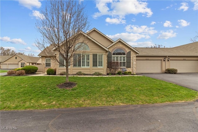 4004 Coventry Ln, Huron, OH 44839 - ranch-style house featuring asphalt driveway, an attached garage, a front yard, stone siding, and a shingled roof