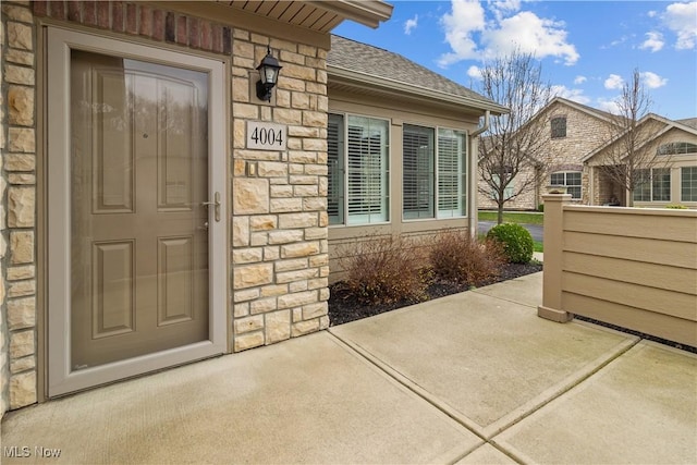 4004 Coventry Ln, Huron, OH 44839 - property entrance with stone siding, roof with shingles, and a patio area
