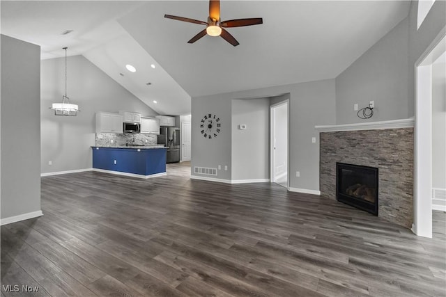 4004 Coventry Ln, Huron, OH 44839 - unfurnished living room with ceiling fan, a fireplace, dark wood-type flooring, high vaulted ceiling, and baseboards