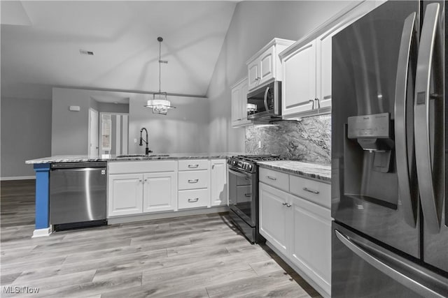 4004 Coventry Ln, Huron, OH 44839 - kitchen featuring appliances with stainless steel finishes, a sink, a peninsula, vaulted ceiling, and white cabinetry