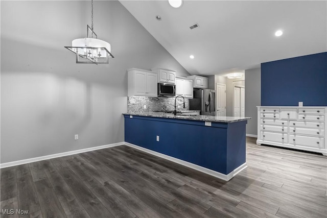4004 Coventry Ln, Huron, OH 44839 - kitchen featuring stainless steel appliances, white cabinets, stone counters, a peninsula, and high vaulted ceiling