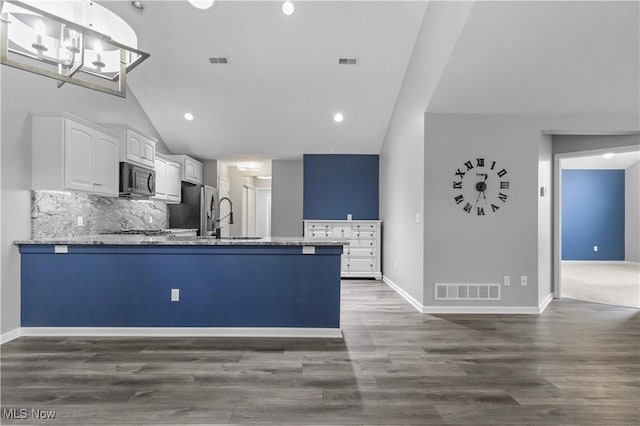4004 Coventry Ln, Huron, OH 44839 - kitchen with stainless steel appliances, a peninsula, white cabinetry, backsplash, and dark wood finished floors