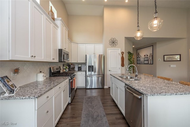 12136 White Tail Run, Columbia Station, OH 44028 - kitchen featuring appliances with stainless steel finishes, a sink, high vaulted ceiling, white cabinets, and a kitchen island with sink