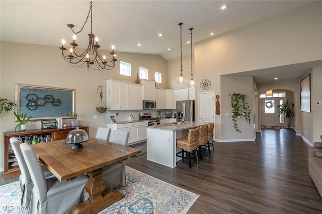 12136 White Tail Run, Columbia Station, OH 44028 - dining area with high vaulted ceiling, arched walkways, dark wood-type flooring, a chandelier, and baseboards