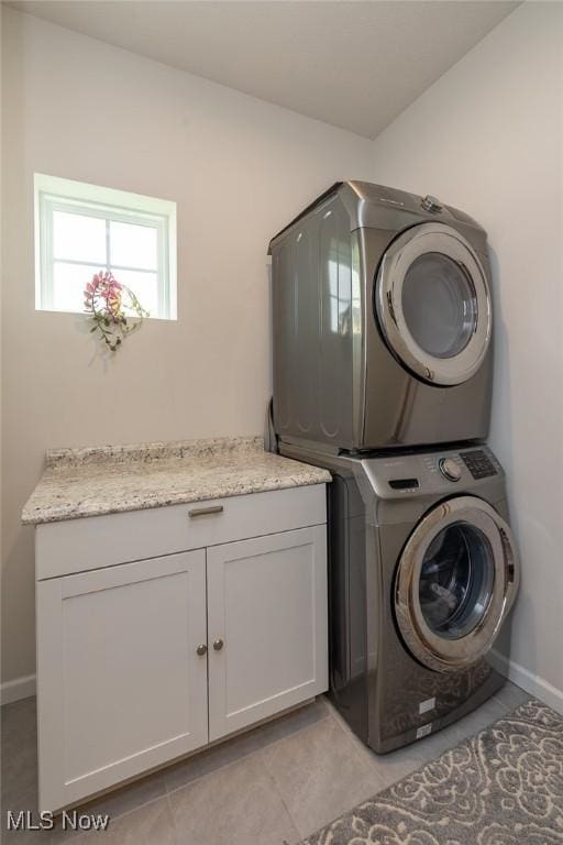 12136 White Tail Run, Columbia Station, OH 44028 - laundry room featuring stacked washer and clothes dryer, cabinet space, and baseboards